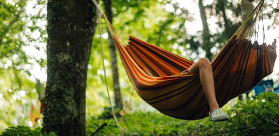 A leg hanging from a hammock in camp site in forrest.